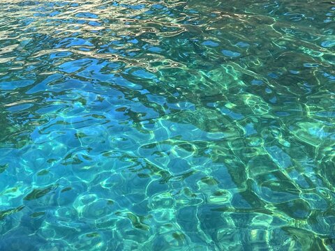 Sea water clear turquoise shiny transparent surface.