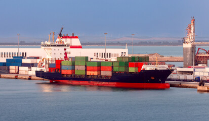 Large container ship in the cargo port of Cadiz at sunset. © pillerss