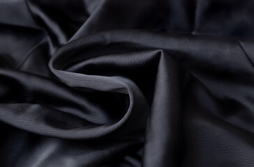 Black crumpled fabric folds background.  Black History Month concept. Soft focus texture of the silk fabric, soft black