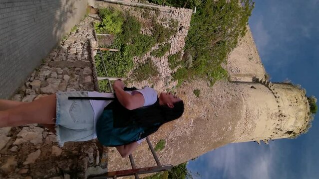 Vertical video a tourist walking next to the Angevin-Aragonese Castle