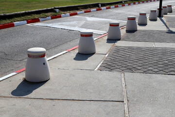 A row of pillars along the road for the safe passage of pedestrians along the sidewalk.