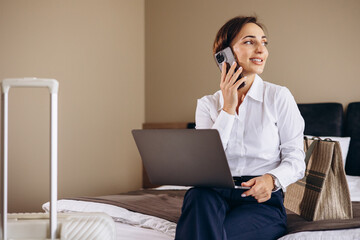 Business woman working on laptop from a hotel room