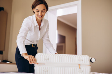 Business woman packing bag in her hotel room