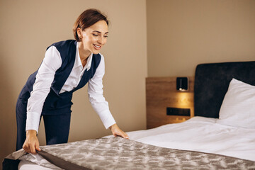 Woman housekeeper preparing bed cloths in the hotel room