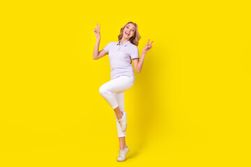 Full size photo of cheerful cute woman dressed purple t-shirt white pants flying showing v-sign...
