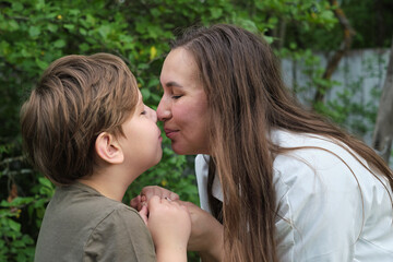 Fototapeta premium In a serene green setting, a mother s hug is a sanctuary of love and comfort for her young son