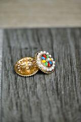 closeup the pair of multicolor ear ring on the grey brown tiles soft focus natural grey brown background.