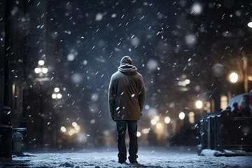 Fototapeten Man walking in the winter city at night under heavy snowfall. © TheCatEmpire Studio