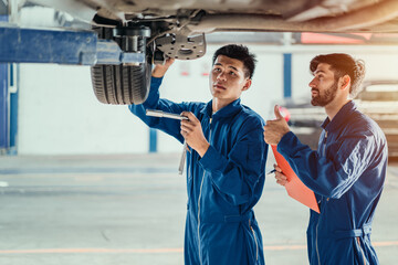 Vehicle service maintenance handsome men checking under car condition in a workshop customer....