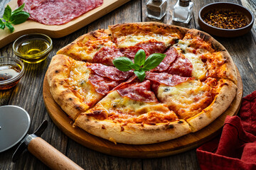 Circle pepperoni pizza with mozzarella cheese on wooden table
