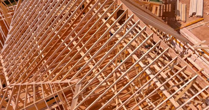 Building new house roof using wooden frame trusses for support beams as of construction process