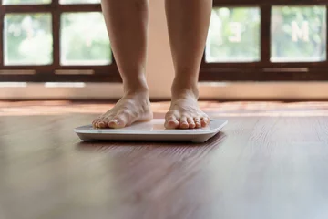 Foto op Plexiglas Fat diet and scale feet standing on electronic scales for weight control. Measurement instrument in kilogram for a diet control © Charlie's