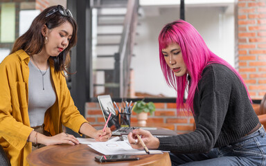 LGBTQ+ transgender man Beautiful Authentic Specialist with Pink Hair and Non-binary trans working together Working Design in creative workplace team work colleagues Gender equality
