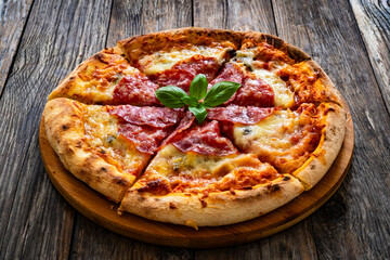 Circle pepperoni pizza with mozzarella cheese on wooden table
