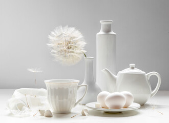 White still life with white dishes on a white background
