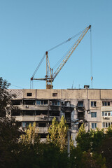 a construction crane is rebuilding a burnt house