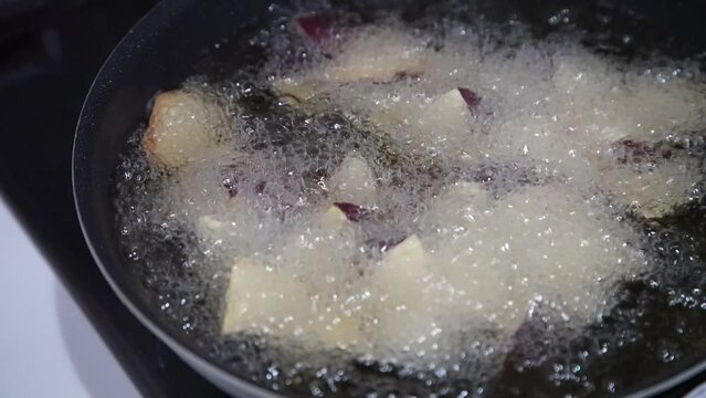 サツマイモを揚げる様子