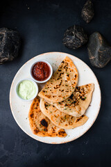 Snack fried flatbread with greens and sauces.