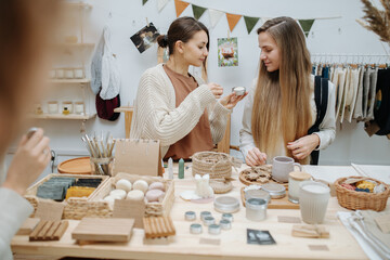 A girl shows her friend what she liked among the products of an eco store