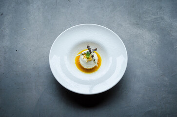 Creamy white chocolate mousse topped with caramel sauce and decorative garnishes, elegantly served on a white plate for a sophisticated dessert