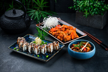 Asian set of chicken fillet with carrot, onion, celery, cashew nuts, sushi roll set with eel, Philadelphia cheese and stewed vegetables.