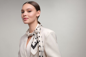 Close up portrait of a beautiful elegant woman with stylish jewelry on a white gray background....