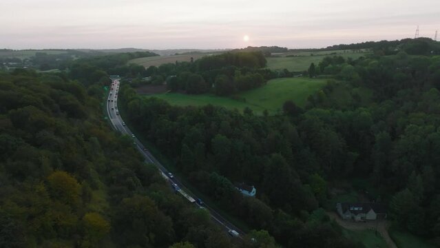 Aerial shot of a busy road through the British countryside at sunrise