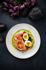 Bruschetta with salmon slices, cream cheese, greens, eggs and vegetable salad.