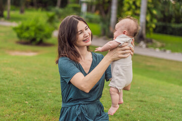 A happy 40-year-old mother cradles her newborn in a sun-drenched park. Love, family and generations in harmony