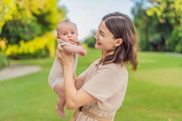 A happy 40-year-old mother cradles her newborn in a sun-drenched park. Love, family and generations in harmony