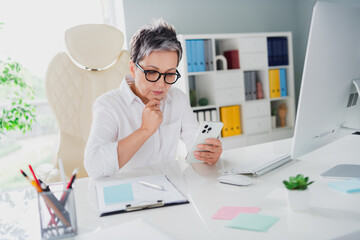 Photo of minded senior businesswoman touch chin deep thinking analyzing her notes send colleagues...