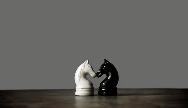 Vintage chess pieces, black and white knight on dark gray background. Chess sports wallpaper. Minimalism. Copy space