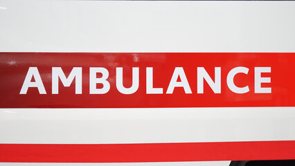 Large ambulance sign on the back door of the car.