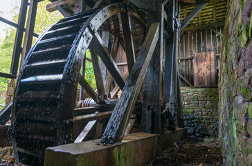 Giant colonial American hydro power wooden water wheel with mechanism and spokes visible inside...
