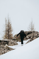 Hombre caminando hacia la cima de la montaña con nieve , en Dolomitas Italia 