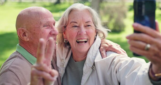 Peace sign, selfie and senior couple kiss at park for love, support and bonding together for care. V hand, happy elderly man and woman in garden for photography, picture and romance outdoor in nature