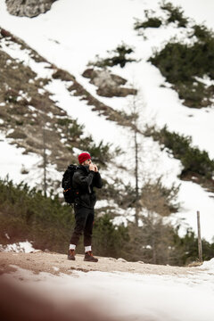 Hombre con mochila en la monta&ntilde;a con nieve calent&aacute;ndose las manos , Alpes italianos , Dolomitas.