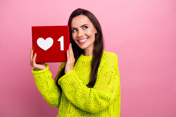 Photo of cute dreamy adorable girl dressed yellow sweater look empty space hold one social media like isolated on pink color background