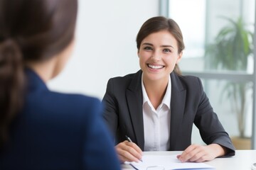 Smiling Female Manager Interviewing an Applicant In Office
