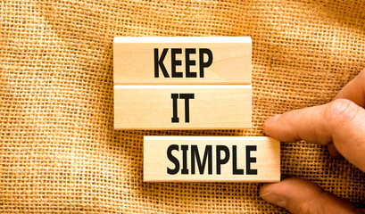 Keep it simple symbol. Concept word Keep it simple on beautiful wooden block. Businessman hand....