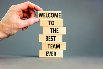 Welcome to best team symbol. Concept words Welcome to the best team ever on wooden block. Beautiful grey table grey background. Businessman hand. Business motivational and welcome to best team concept