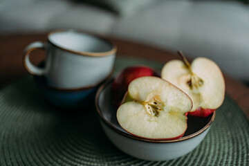 Two red ripe apples on a green napkin. The apple is cut in half. Two halves of an apple. One apple...