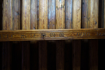Antique larch ceiling beam with carved ornaments in the fireplace room of a tenement house 