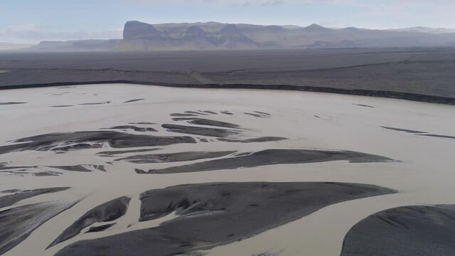 Slow backward drone flight over the glacial floodplain Skei&eth;ar&aacute;rsandur with braiding rivers and volcanic debris in the south of Iceland