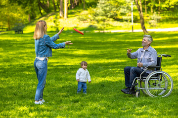 Parents a nd a cute kid playing frisbee and looking happy