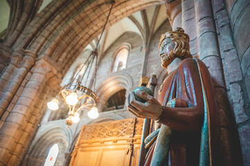 King holding rich apple, axe and a cross, indoors at St Magnus Cathedral, low angle side view,...