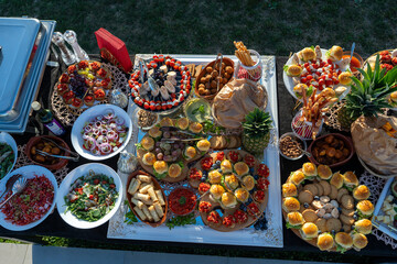 A table full of various dishes, small bites, outdoor party catering spread. © DusanJelicic