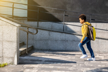 Schoolboy with backpack going home from school