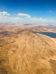 Fototapeta na wymiar Aerial photography of the Nevada desert, United States, you can see the mountains, the desert plain, a lake with a river, the clouds and the sky.