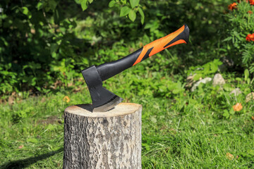 Steel axe with plastic handle stuck into an aspen stump